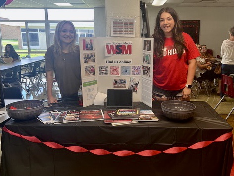 Left, print editor-in-chief Addison Mikula and, right, video executive producer Kendall Drobish work the Weir Student Media table during the freshman orientation club fair.