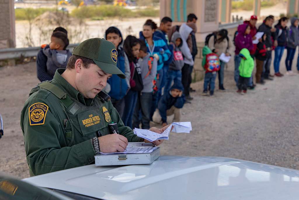 Border patrol agent apprehending migrants who surrendered in El Paso, Texas.