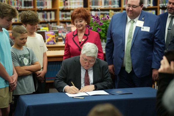 Patrick Morrisey signs House Bill 2003 and Senate Bill 280. Students of Lincoln Middle School as well as Del. Mickey Petitto, R-Harrison and Carl Martin, R-Upsher watch. (West Virginia Office of the Gov. Patrick Morrisey | Courtesy photo) 