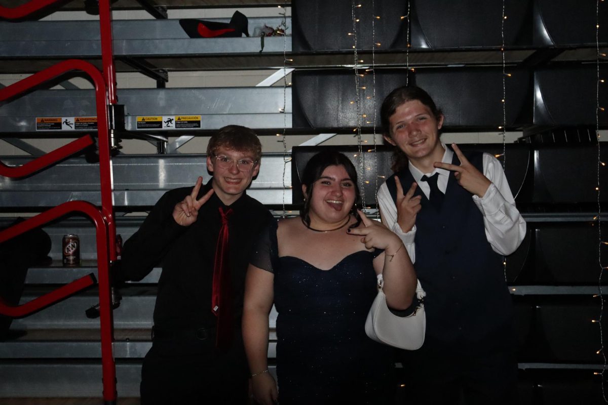 Jackson Owens, Tori Fetty, Clint Coston hold up peace signs for a picture.