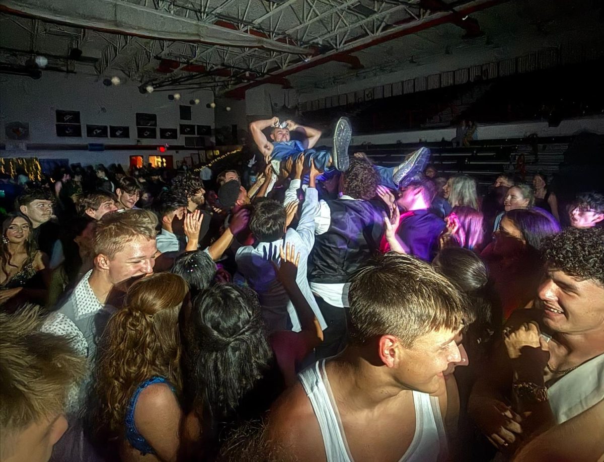 The homecoming spirit fills the gym when the students raise homecoming king Jackson Bonner into the air.  