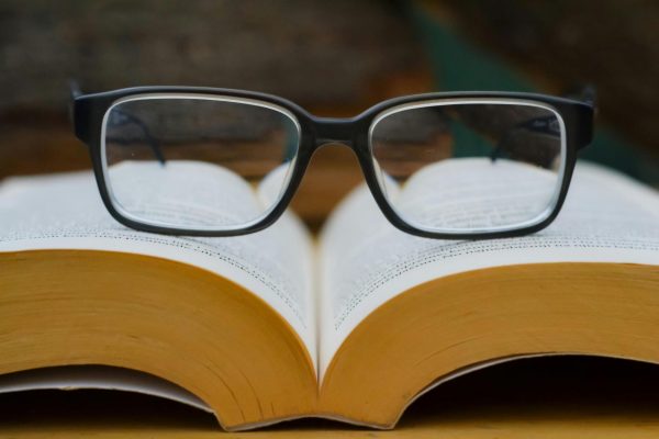 A pair of glasses resting on a book.
Photo taken by Djordje Vezilic from Pexels.com